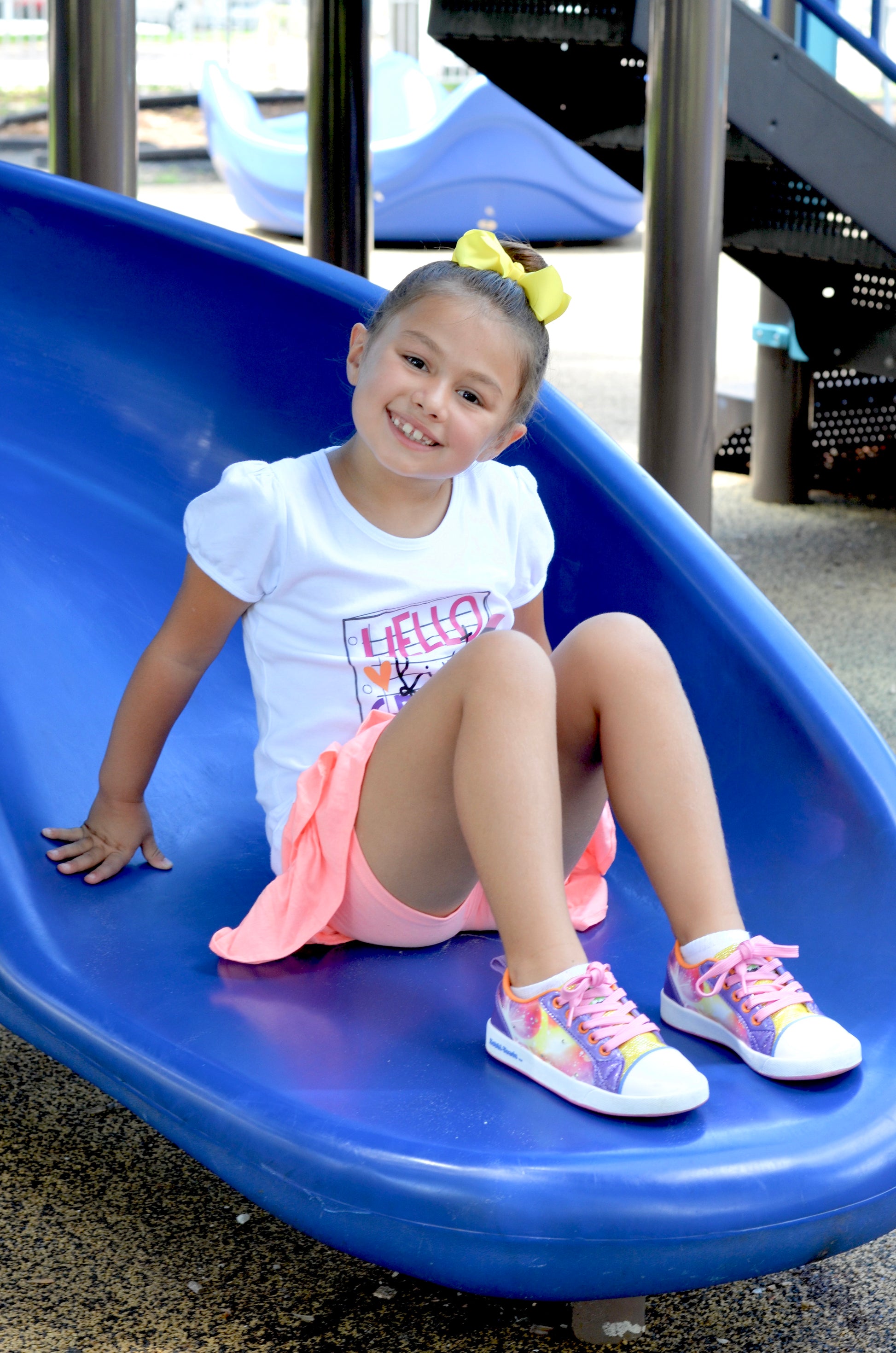 Child sliding down a blue slide at a playground